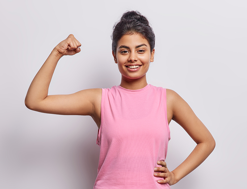 sporty woman raises arm and shows biceps